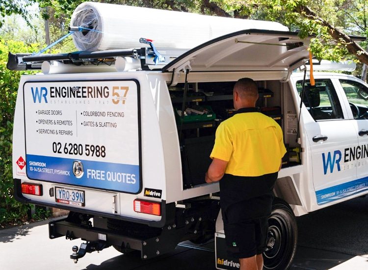 WR Engineering technician accessing tools from service ute during a garage door repair in Canberra.